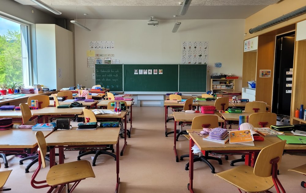 机が並ぶ小学校の教室のイメージ